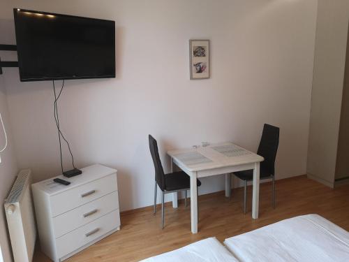 a room with a table and a tv and a table and chairs at Apartament Trzy Korony 1 in Świnoujście