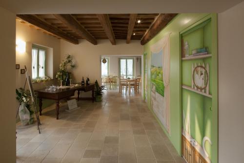a hallway with green walls and a dining room at Le Maraclà Country House in Iesi