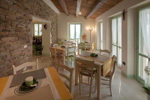 a dining room with tables and chairs and a brick wall at Le Maraclà Country House in Iesi