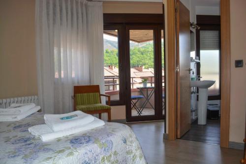 a bedroom with a bed and a view of a balcony at Pension Reconquista in Cangas de Onís