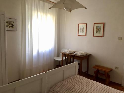 カルドナッツォにあるAppartamento Balùのベッドルーム1室(ベッド1台、テーブル、窓付)