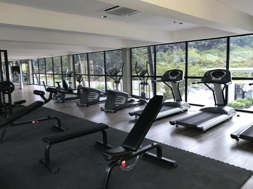 a gym with a lot of treadmills and ellipticals at Hyve Soho Family Resort Suites in Cyberjaya