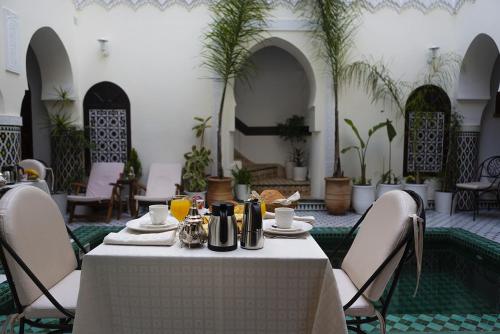 a table with a white table cloth in a room at Riad Maison Belbaraka in Marrakech