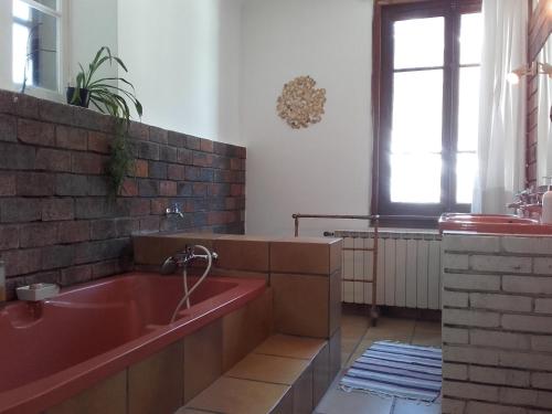 a bathroom with a red tub and a window at Barthoux in Seythenex