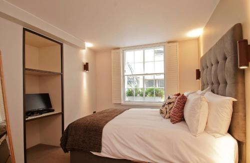 ein Schlafzimmer mit einem großen Bett und einem Fenster in der Unterkunft Wigmore Suites Serviced Apartments by Globe Apartments in London