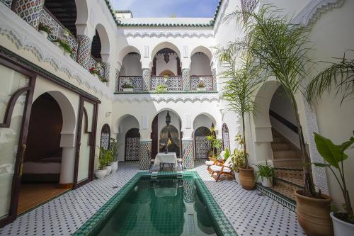 une cour avec une piscine dans un bâtiment dans l'établissement Riad Maison Belbaraka, à Marrakech