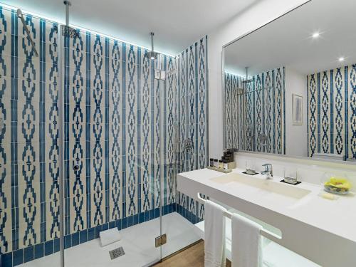 La salle de bains est pourvue d'un lavabo et d'un miroir. dans l'établissement H10 Ocean Dunas - Adults Only, à Corralejo