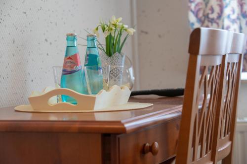 a table with two bottles and glasses on it at Haus Schlematal Hotel und Restaurant in Bad Schlema