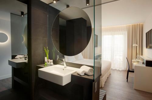 bagno con lavandino e specchio di H10 Port Vell 4* Sup a Barcellona