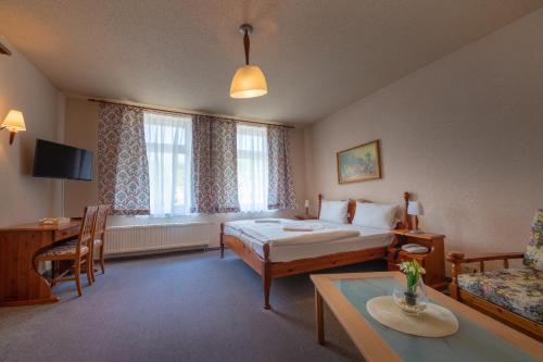 um quarto de hotel com uma cama e uma mesa em Haus Schlematal Hotel und Restaurant em Bad Schlema