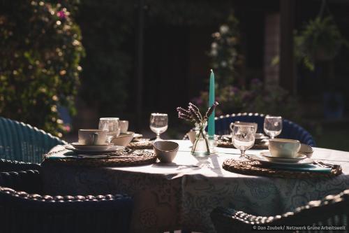 a table with a white table cloth and plates and glasses at Sa Vaqueria in Porto Cristo