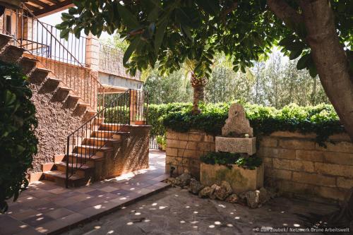 a brick building with a staircase and a tree at Sa Vaqueria in Porto Cristo