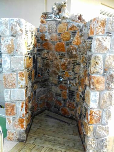 a stone wall with a shower in a bathroom at Villa Aeolus with private overflow, endless, heated pool in Prinés