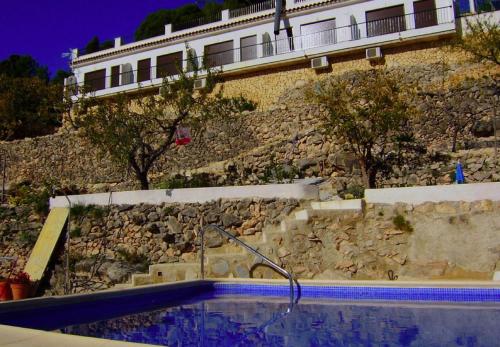 a swimming pool with a hose in front of a building at Alojamientos Turisticos Isa i Toni in Sella