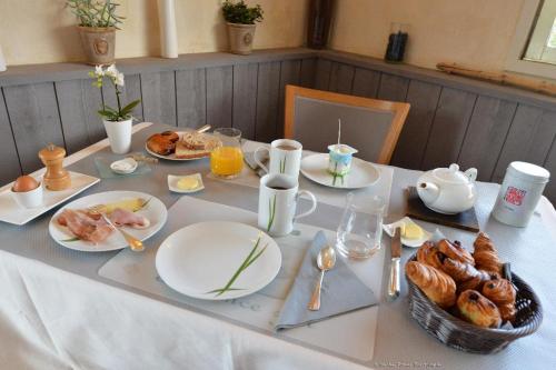 a table with plates of food and eggs and croissants at Logis Le Gavrinis in Baden