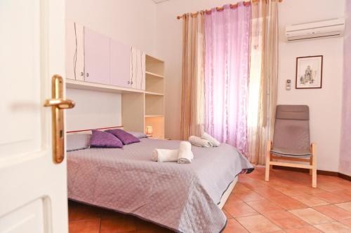 1 dormitorio con 1 cama y 1 silla en Garibaldi B&B, en Cefalú