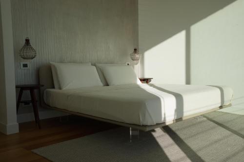 a white bed in a bedroom with a table at Villa Crassula in Casarza Ligure