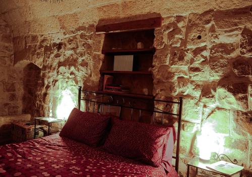 een slaapkamer met een bed in een stenen muur bij Casa Vacanze Vico Farinella in Polignano a Mare