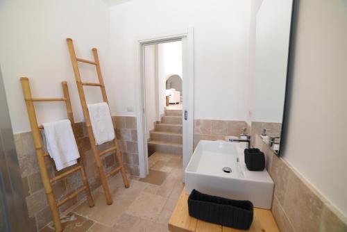 a bathroom with a white sink and a mirror at Trulli Paola in Ostuni