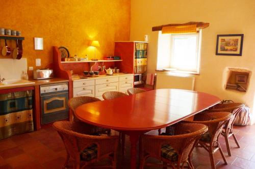 a kitchen with a wooden table and chairs at La Hulotte in Limogne-en-Quercy