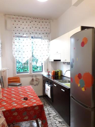 a kitchen with a stainless steel refrigerator and a table at La casa di Laura in Bologna