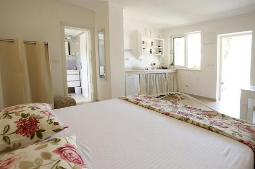 een slaapkamer met een wit bed met bloemen erop bij PERE in Korčula