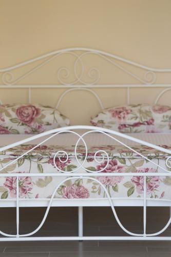 a white bed with pink flowers on it at PERE in Korčula