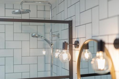 een badkamer met een douche en een spiegel bij Appartementen Zeerust in De Koog