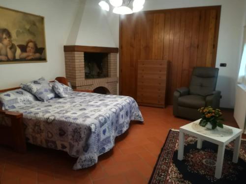 a bedroom with a bed and a chair and a fireplace at Villa Pancrazzi in Figline Valdarno