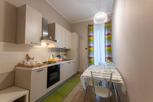 kuchnia ze stołem i krzesłami w pokoju w obiekcie B&B Cairoli w mieście Mesyna