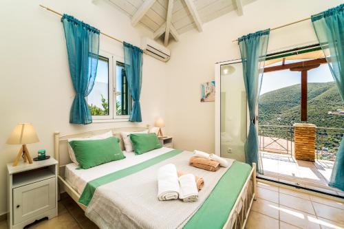 a bedroom with a bed with blue curtains and a window at Villa Emma in Sivota