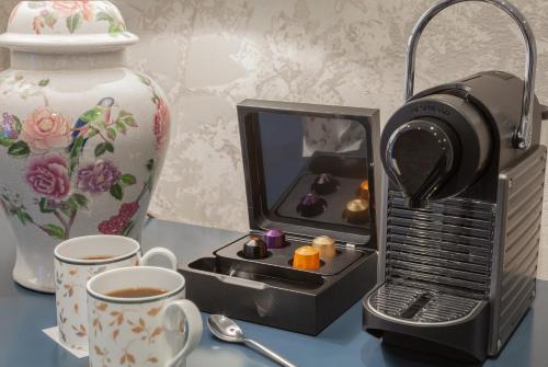 a tea set with a cup of coffee and a camera at Richmond Hill Hotel in Richmond upon Thames
