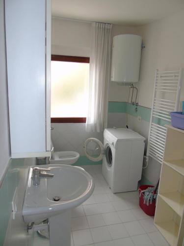リニャーノ・サッビアドーロにあるCondominio Nautilusのバスルーム(シンク、洗濯機付)