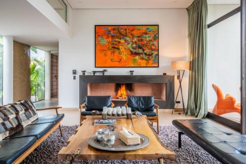 a living room with a table and a fireplace at Zagora and Marhba villas Marrakech - by EMERALD STAY in Marrakech