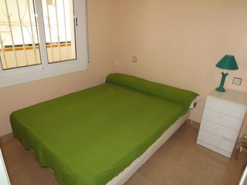 - un lit vert dans une chambre avec fenêtre dans l'établissement Mediterráneo, à Roses