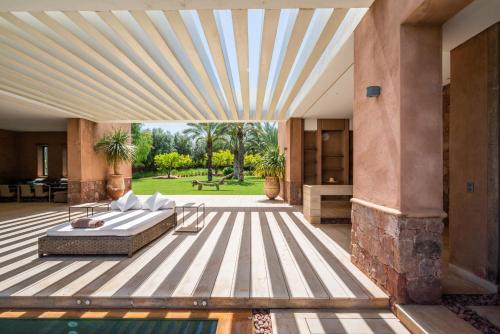 a bedroom with a bed on a deck next to a pool at Zagora and Marhba villas Marrakech - by EMERALD STAY in Marrakech