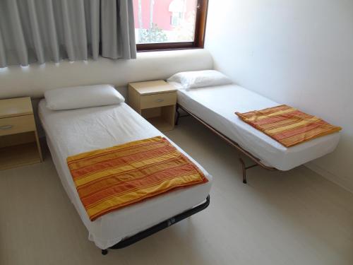 利尼亞諾薩比亞多羅的住宿－Condominio Nautilus，一间卧室设有两张床和窗户。