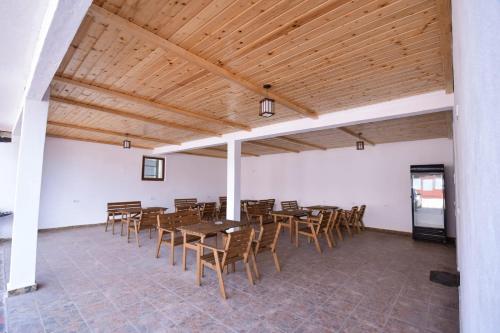 uma sala de jantar com tectos e mesas e cadeiras de madeira em Pensiunea Cristina em Vişeu de Sus