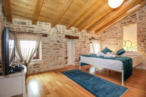 a bedroom with a bed in a brick wall at Villa Castel in Bale