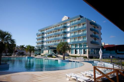 un hotel con piscina frente a un edificio en Oceania Park Hotel Spa & Convention en Florianópolis