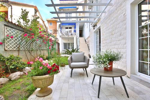 a patio with a chair and a table and flowers at Marinero Apartments in Budva