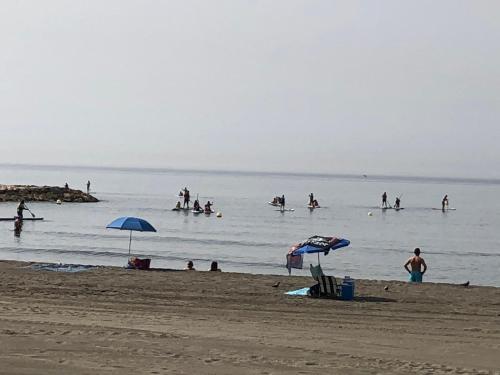 a group of people in the water at the beach at Apartamentos casa Tia Antonia in Málaga