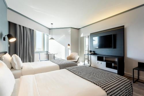 a hotel room with two beds and a flat screen tv at HF Fénix Porto in Porto