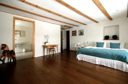 una camera con un grande letto e un pavimento in legno di La Ferme de la Praz B&B a La Praz