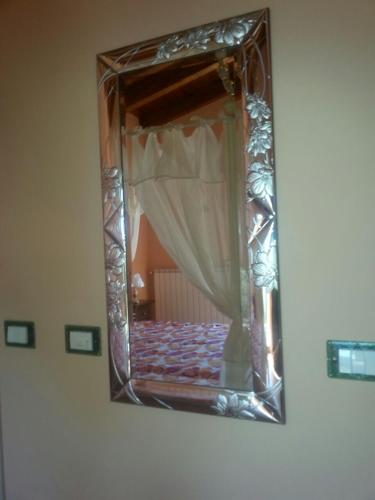 a mirror on a wall with a bed with a curtain at Domus Quarticelli Costa dei Trabocchi in Torino di Sangro