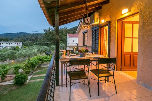 un patio avec une table et des chaises sur un balcon dans l'établissement GREEN and BLUE VILLA, à Glykadi