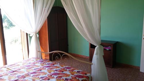 a bedroom with a bed with curtains and a window at Domus Quarticelli Costa dei Trabocchi in Torino di Sangro