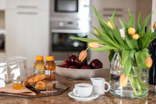 eine Theke mit einer Vase aus Blumen und einem Tisch mit Essen in der Unterkunft Il Biotto - Adults only in SantʼAmbrogio di Valpolicella