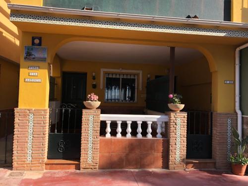 a front porch of a house with two potted plants at Apartamentos casa Tia Antonia in Málaga