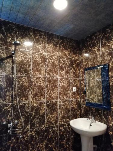 a bathroom with a sink and a mirror at Guest House Machaxela in Gonio